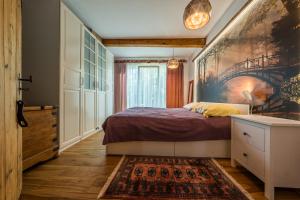 1 dormitorio con 1 cama y una pintura en la pared en prawdziwy wiejski domeczek, en Hajnówka