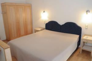 a bedroom with a large white bed with a blue headboard at Loft Kalamaja in Tallinn +8 photos