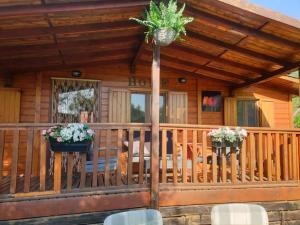 a porch of a wooden cabin with potted plants at Brevar Vakantie - Porlezza in Porlezza