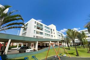 a large white building with a playground in front of it at Hotel Premier Residence Brasília - Ozped Flats in Brasilia