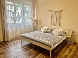 a bed in a room with a large window at Eva's Apartment Prague in Prague