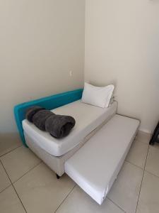 a bed in a room with a pillow on it at Pousada Gil in Olímpia