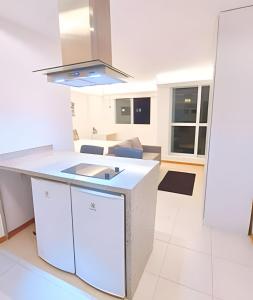 een keuken met witte werkbladen en een fornuis met oven bij Hotel Saint Moritz Brasília - Ozped Flats in Brasilia