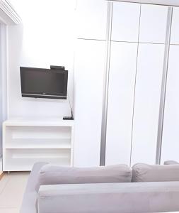 a living room with two white couches and a tv at Hotel Saint Moritz Brasília - Ozped Flats in Brasília