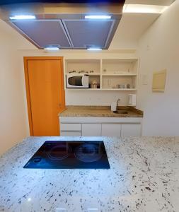 a kitchen with a counter top with a microwave at Hotel Saint Moritz Brasília - Ozped Flats in Brasília