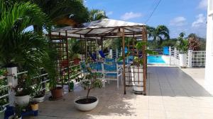 a patio with a pergola and chairs and a pool at Coconing logements studios et maisons in Sainte-Anne