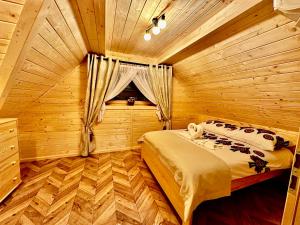 a bedroom with a bed in a wooden cabin at Góralska Osada Tatra House z jacuzzi in Białka Tatrzańska