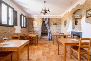 un restaurante con mesas y sillas de madera y chimenea en La iaia Merce, en L'Aldea