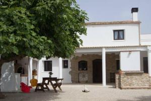 una casa blanca con una mesa de picnic delante de ella en La iaia Merce, en L'Aldea