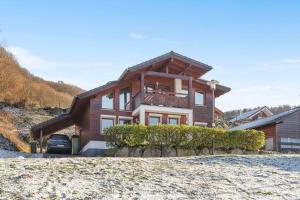 una casa de madera con un coche aparcado delante de ella en Luxus-Wellness-Haus am Waldsee en Rieden