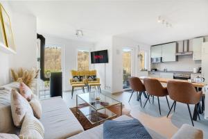 a living room with a couch and a table at Luxus-Wellness-Haus am Waldsee in Rieden