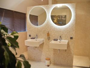 a bathroom with two sinks and a mirror at Bed & Brochje Burgum in Burgum +45 photos