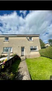 a large brick house with a green lawn in front of it at Fort William - Highland holiday home in Fort William