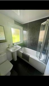 uma casa de banho com um lavatório, uma banheira e um WC. em Fort William - Highland holiday home em Fort William