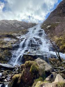a waterfall on the side of a mountain at Fort William - Highland holiday home in Fort William