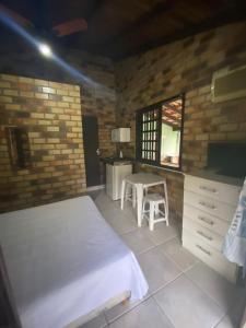 1 dormitorio con cama, mesa y TV en Residencial da Casinha, en Garopaba