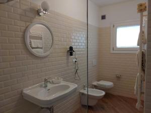 オルビアにあるRMaison Luxury Suites Olbiaのバスルーム(洗面台、トイレ、鏡付)