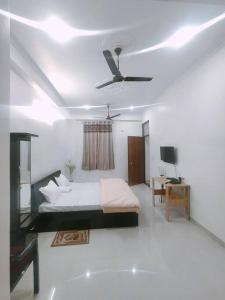 um quarto com uma cama e uma ventoinha de tecto em Bayweaver nests homestay Vishal khand 102 em Lucknow