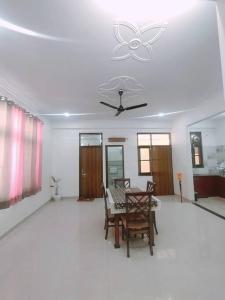 uma sala de jantar com uma mesa e uma ventoinha de tecto em Bayweaver nests homestay Vishal khand 102 em Lucknow