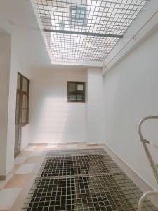 a white room with a black grate on the floor at Bayweaver nests homestay Vishal khand 102 in Lucknow