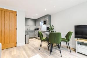 a kitchen with a table and green chairs in a room at No.44 - Deluxe 2-Bedroom Duplex with Balcony in Stoney Middleton