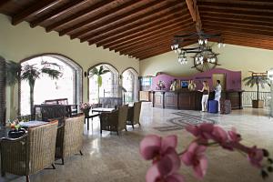 a lobby with tables and chairs and a woman standing in a room at Club Anastasia - Family Hotel in Marmaris