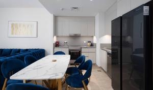 a living room with a table and blue chairs at Manzil - 2BR Family Styled Apartment in Dubai Creek with Beach Access in Dubai