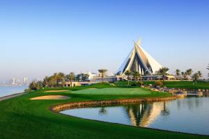 a golf course with a church and a pond at Manzil - 2BR Family Styled Apartment in Dubai Creek with Beach Access in Dubai