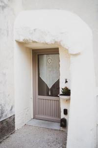 a front door of a white building with a potted plant at L'évasion de Bedoin, appartement in Bédoin