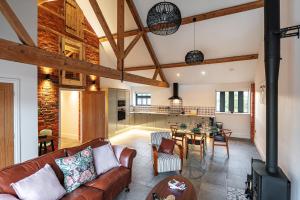 un soggiorno con un divano e un tavolo di Pigeon House - Unique Barn with private garden, hot tub and wood burner a Shrewsbury