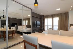 a dining room and living room with a table and chairs at Hotel Vision Brasília - Ozped Flats in Brasília