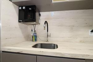 a kitchen counter with a sink and a microwave at Hotel Vision Brasília - Ozped Flats in Brasilia