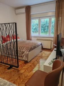 um quarto com uma cama, uma secretária e 2 janelas em Britstreet apartment em Zagreb