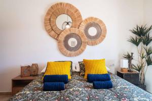 1 dormitorio con 1 cama con almohadas amarillas y azules en Villa Safari, en Costa Calma