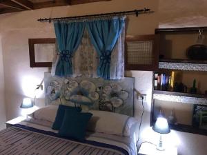 - une chambre avec un grand lit et des rideaux bleus dans l'établissement Casa rural con Wifi y estupenda vista a la montaña en Hermigua, à Hermigua