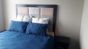 a bed with blue and white pillows on it at Braam vibes retreat in Johannesburg
