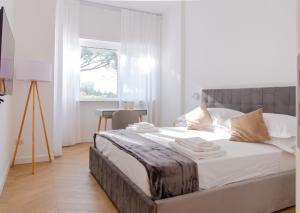 a bedroom with a large bed with white sheets and a window at Roma Eur terrazzo vista Laghetto Modigliani in Rome