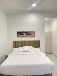 ein Schlafzimmer mit einem großen Bett mit weißer Bettwäsche in der Unterkunft AL Rabie Resort ,Nizwa Grand Mall in Firq
