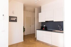 a kitchen with white cabinets and black counter tops at Eur terrazzo vista Laghetto Modigliani in Rome