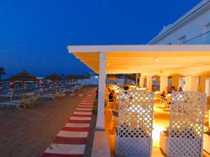a pavilion with a red and white striped carpet on the beach at Albergo Diomedee Rooms on the Beach in Rodi Garganico