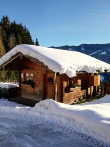 a cabin covered in snow with a pile of snow at Bauernhof Bachgut in Mühlbach am Hochkönig