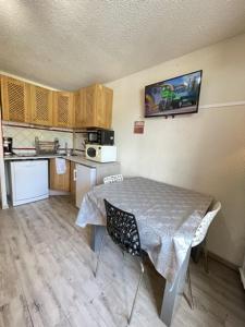 a small kitchen with a table and a kitchen with a counter at Appartement risoul, 1 pièce , 4 personnes in Risoul