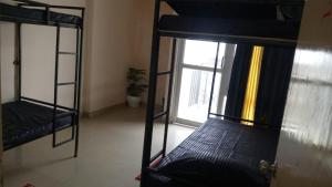 two bunk beds in a room with a window at Bayweaver nests homestay in Royal plaza 905 in Lucknow