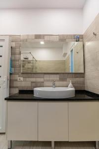 a bathroom with a white sink and a mirror at VILA LLANO in Vlorë