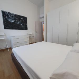 a bedroom with a white bed and a painting on the wall at BnButler - Grasselli, 8 - Comfy and Newly Renovated in Milan