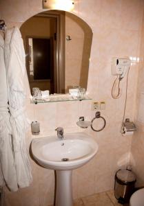 ein Bad mit einem Waschbecken und einem Spiegel in der Unterkunft Gonchar Hotel in Kiew