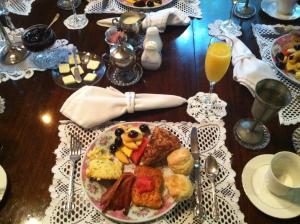 a table with a plate of breakfast food and orange juice at Corners Mansion Inn - A Bed and Breakfast in Vicksburg