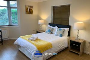 牛津的住宿－6 Bedroom House by Beds Away Short Lets & Serviced Accommodation Oxford With 2 En-suites, Garden & Free Parking，一间卧室配有一张大床和两盏灯
