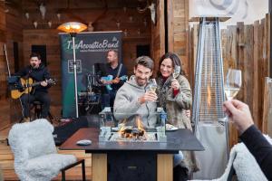 a man and a woman sitting around a table with a fire at SKI - GOLF - WELLNESS Hotel Riml in Hochgurgl