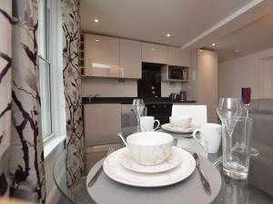 een keuken met een glazen tafel met borden erop bij Home from Home - Greenwich House in Chester